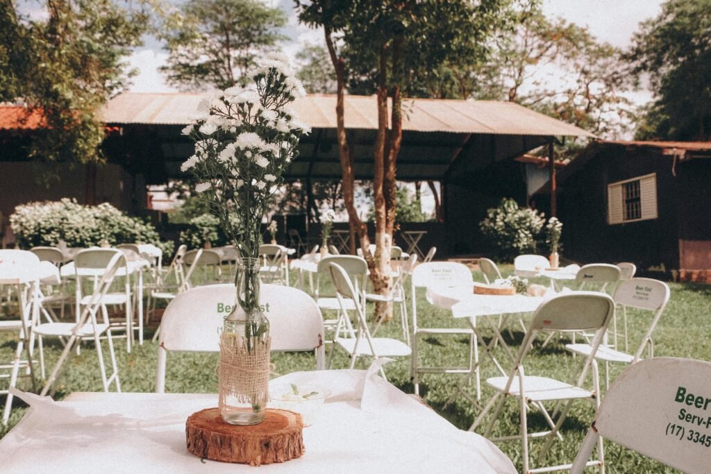 Charming outdoor garden event setup with floral centerpiece on a sunny day.